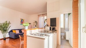 A compact living space with a kitchenette, a sofa, a dining table, and a bathroom. - Welcome Dhome, Cozy penthouse with St. Peter View (Roma)