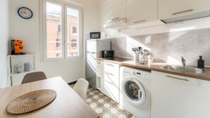 A compact kitchen with a washing machine, a microwave, and a sink. - Casetta Giolitti, Cozy Apartment in the Heart of Rome (Roma)