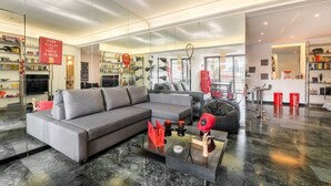 A modern living room with a grey sofa, a glass coffee table, and a red sign. - Comics Roma Penthouse, Funny Flat Nearby Colosseum (Roma)