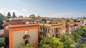 A residential area with terracotta-tiled buildings, balconies, and lush greenery. - Comics Roma Penthouse, Funny Flat Nearby Colosseum (Roma)
