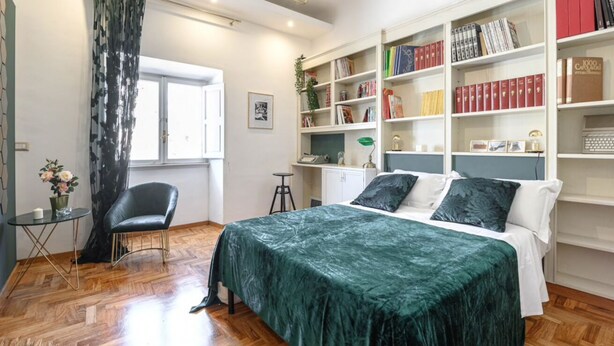 A bedroom with a bed, a chair, a desk, a bookshelf, and a window. - GLAM 50 - Exclusive Penthouse in the Heart of Rome (Roma)