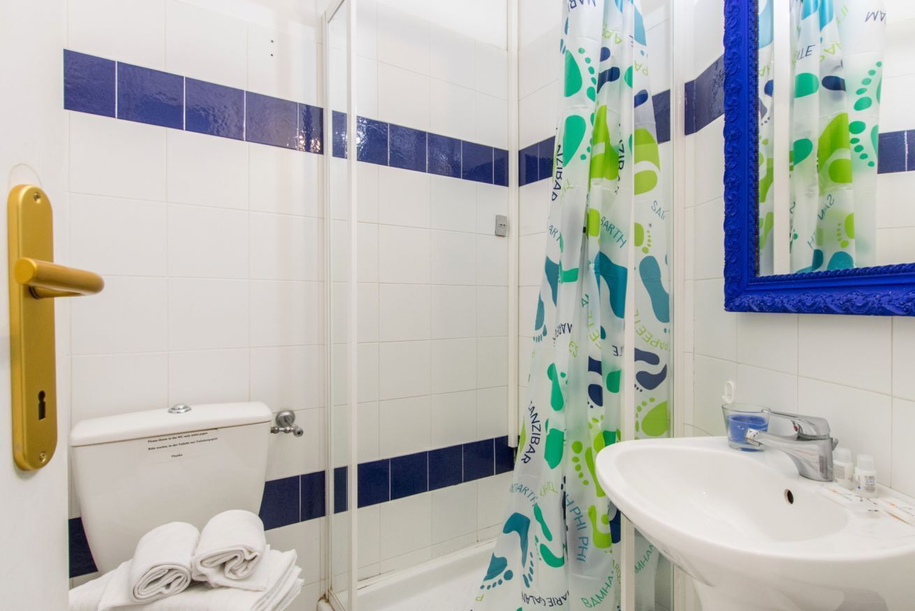 Een badkamer met toilet, douche en wastafel.