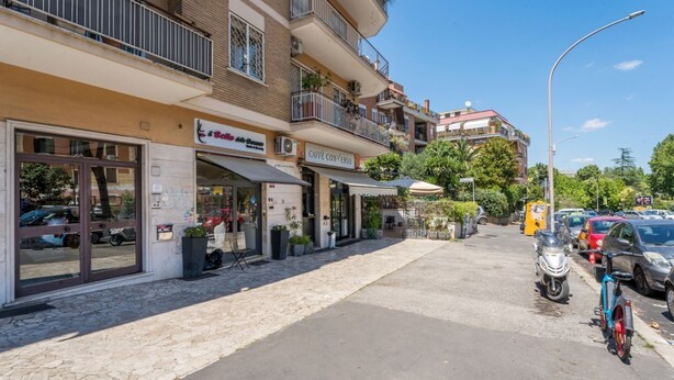 Un edificio con escaparate, mesas al aire libre y una bicicleta estacionada.
