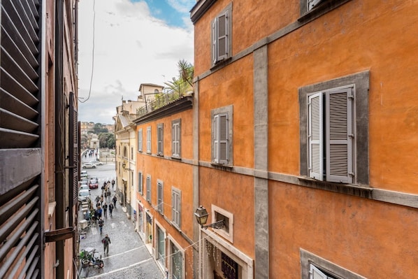 A narrow street with buildings on either side, featuring balconies and shutters. - Maison Regola, Styilish Flat in Campo De Fiori (Roma)