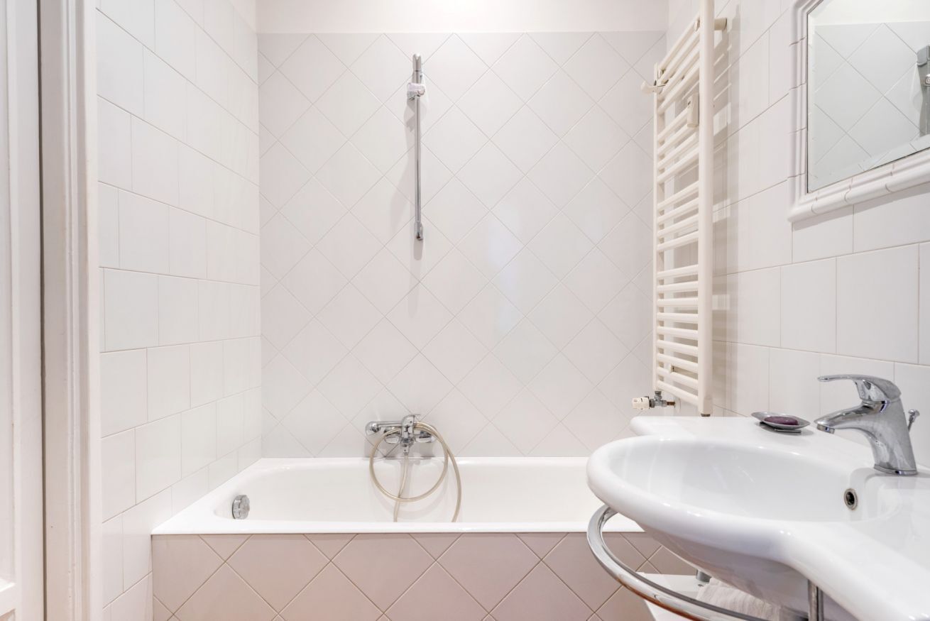 A modern bathroom with a bathtub, a sink, and a mirror.