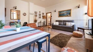 A living room with a sofa, a coffee table, and a TV. - Re Di Roma Vintage, Flat on the Metro Re di Roma (Roma)
