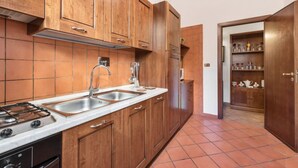 A kitchen with wooden cabinets, a stainless steel sink, and a built-in stove. - Re Di Roma Vintage, Flat on the Metro Re di Roma (Roma)