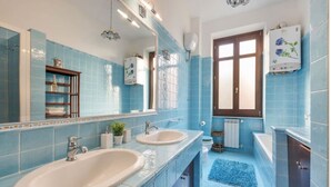 A bathroom with two sinks, a mirror, a radiator, and a window. - Re Di Roma Vintage, Flat on the Metro Re di Roma (Roma)