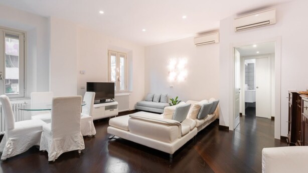A modern living room with a sofa, chairs, a TV, and a dining table. - The Vatican Rest, Elegant Apt Nerby the Basilica (Roma)