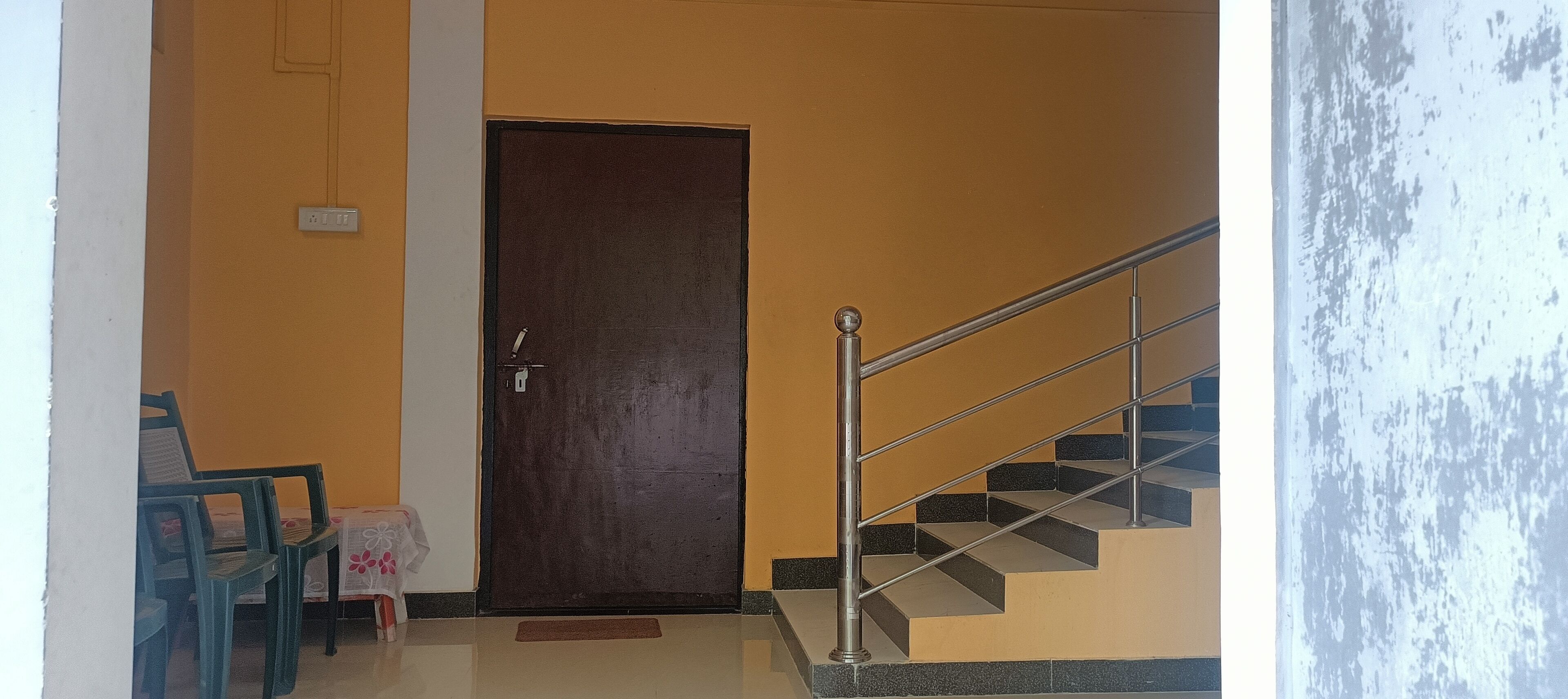 Una escalera con barandillas de metal que conduce a una puerta de madera oscura.