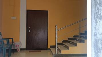 Una escalera con barandillas de metal que conduce a una puerta de madera oscura.
