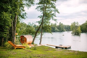 A wooden cabin by a lake with a deck and a lounge chair. - Exceptional Alsatian estate with private lake (Rountzenheim-Auenheim)