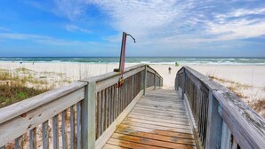 A wooden boardwalk leading to a beach with a cloudy sky. - Finntastic Beachfront House by Liquid Life (Gulf Shores)
