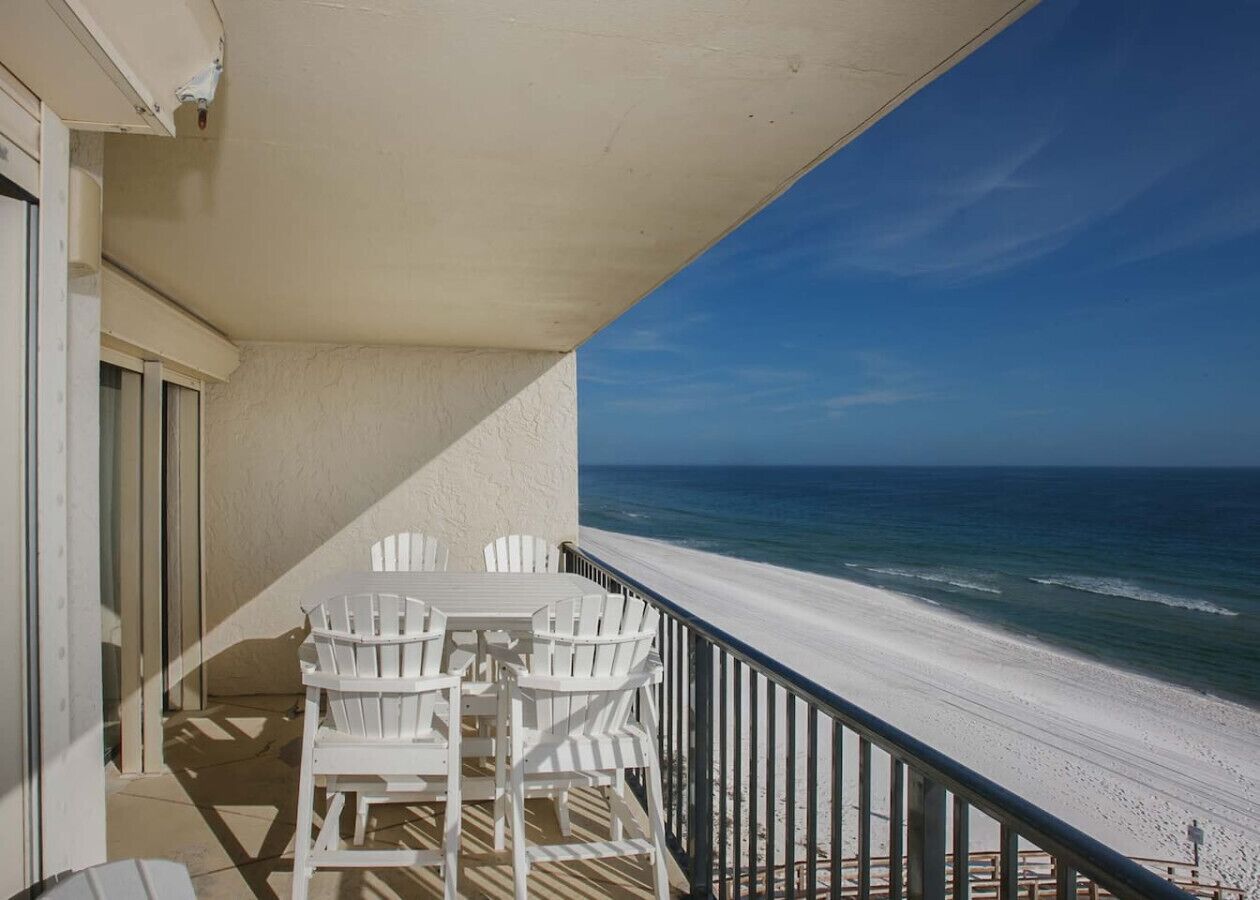 A balcony with a view of the beach and ocean.