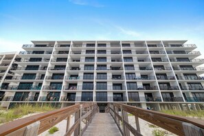 Een hotel met meerdere verdiepingen en een centrale trap die naar de ingang leidt.