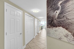 A hallway with white doors and a tiled floor.