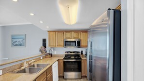 Una cocina moderna con armarios de madera, electrodomésticos de acero inoxidable y encimera de granito.