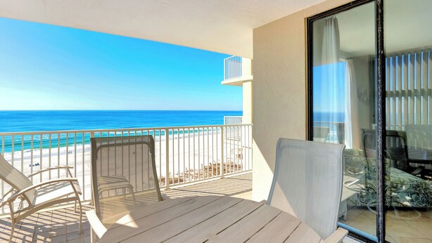 A balcony with a view of the ocean, a table, and two chairs. - Shoalwater 802 by Liquid Life (Orange Beach)