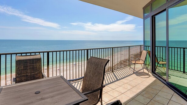 A balcony with a view of the ocean, a table, and two chairs. - The Oasis 1103 by Liquid Life (Orange Beach)