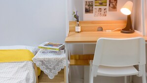 A compact bedroom with a bunk bed, a desk with a chair, a small table with a book, and a bedside table with a lamp. - Only for woman - Sadang House (Seoul)