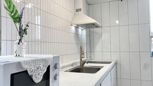 A kitchen with a microwave, oven, and sink. - Only for woman - Sadang House (Seoul)