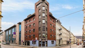 Ein Eckgebäude mit modernem Design, das Ziegel- und Glasfassaden kombiniert.