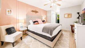 A bedroom with a bed, a chair, a desk, a ceiling fan, and a door leading to a balcony. - Beautiful Community! Pool, Jacuzzi, Tennis, Golf (Palm Springs)