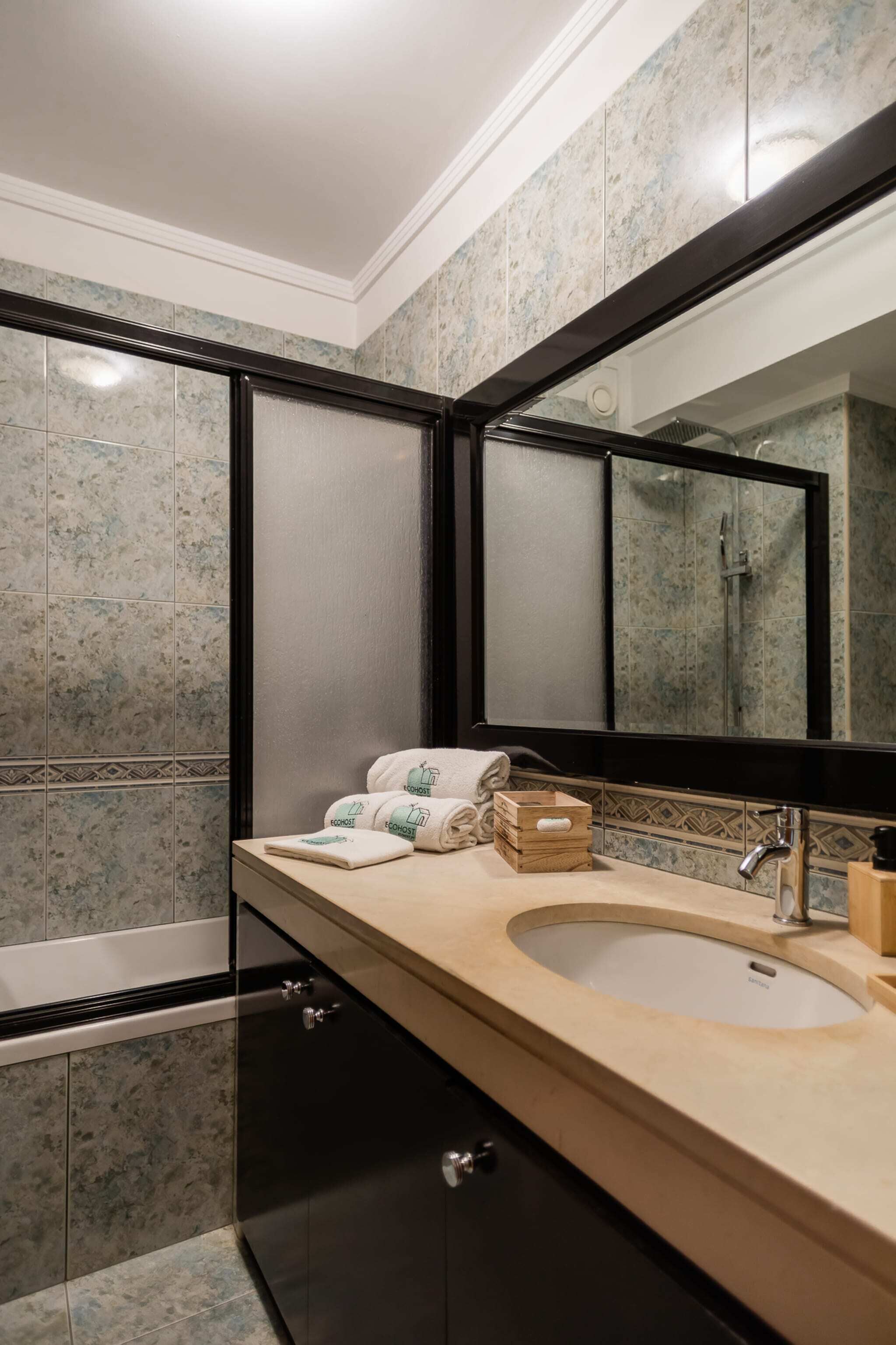 Ein modernes Badezimmer mit einem Doppelwaschbecken, einem großen Spiegel und einer Badewanne.