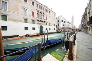 A canal with boats, a bridge, and historic buildings along the water.