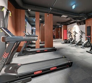 A gym with multiple treadmills, stationary bikes, and a mirrored wall. - Riverside Nadmotławie - Sauna, Gym & Kids Play by Lion Apartments (Gdansk)