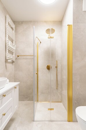 A modern bathroom with a glass-enclosed shower, a white sink, and a towel rack. - Riverside Nadmotławie - Sauna, Gym & Kids Play by Lion Apartments (Gdansk)