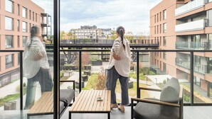 A modern apartment with a balcony, large windows, and a view of other buildings. - Riverside Nadmotławie - Sauna, Gym & Kids Play by Lion Apartments (Gdansk)