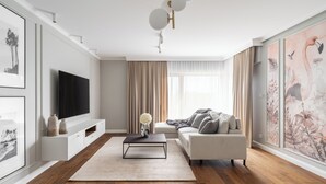 A modern living room with a flat-screen TV, a sofa, a coffee table, and artwork on the walls. - Riverside Nadmotławie - Sauna, Gym & Kids Play by Lion Apartments (Gdansk)