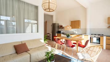 Una sala moderna con un sofá, una mesa de centro y un comedor con una mesa y sillas.