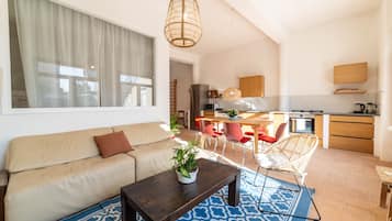 Una sala de estar moderna con sofá, mesa de centro y un comedor con sillas.