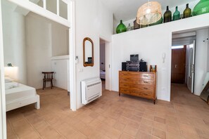 Une chambre à coucher avec un lit, une commode, un miroir et un radiateur.