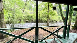 Une terrasse en bois offrant une vue sur une rivière et une forêt.