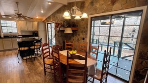 Un coin repas avec un mur en pierre, une table en bois et des chaises.