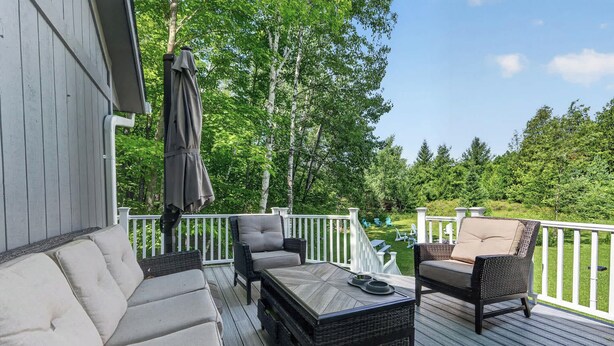 Eine Terrasse mit Gartenmöbeln, darunter eine Sitzecke mit Sofa, Stühlen und einem Tisch.