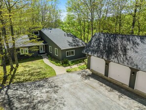 A two-story house with a garage, surrounded by trees and a well-maintained lawn. - Pet friendly home near Baileys Harbor, Door County (Baileys Harbor)