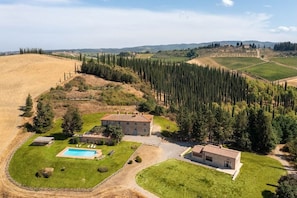 Vista aérea de una propiedad con dos edificios principales, una piscina y un viñedo.