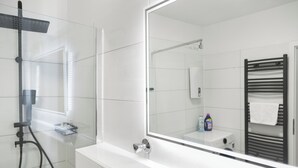 A modern bathroom with a large mirror, a glass shower enclosure, and a towel rack. - VlNFUL2: Premium apartment | balcony | parking space (Mülheim an der Ruhr)