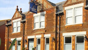 A traditional brick building with a sign reading "Coach Horses." - The Coach & Horses (King's Lynn)