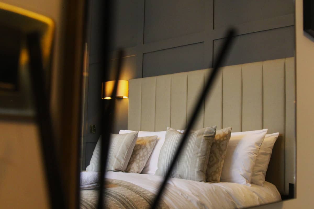 Ein Hotelzimmer mit Bett, Kissen und Kopfteil.