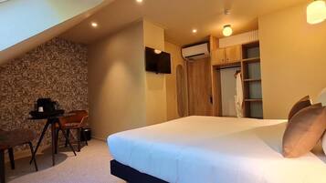 Un dormitorio con cama, escritorio, silla, televisor y armario.