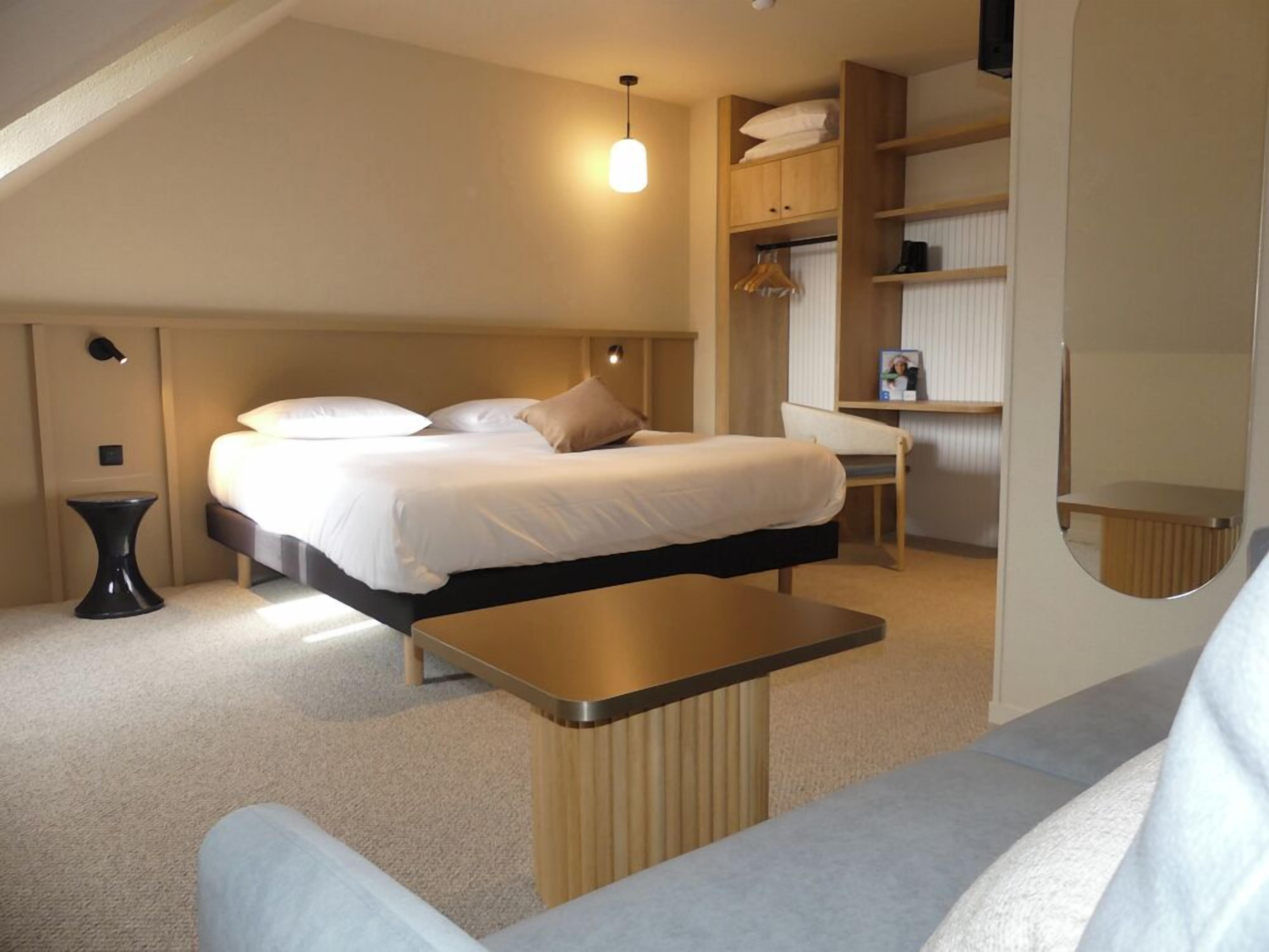 Une chambre à coucher moderne avec un lit, une table de chevet et un bureau.