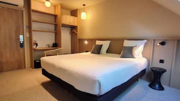 Un dormitorio con una cama grande, un armario y una mesita.