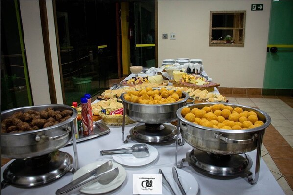 A buffet table with various food items and serving utensils.