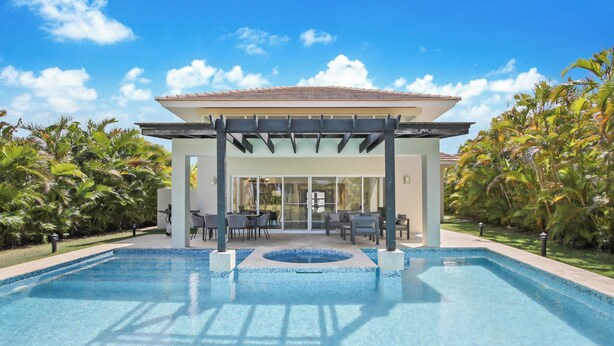 A swimming pool with a covered patio area, surrounded by lush greenery. - Golf Villa in Bavaro - Pool, Jacuzzi, Staff (Punta Cana)