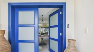 A blue door leading to a dining area with a chandelier, a table, and chairs. - Golf Villa in Bavaro - Pool, Jacuzzi, Staff (Punta Cana)